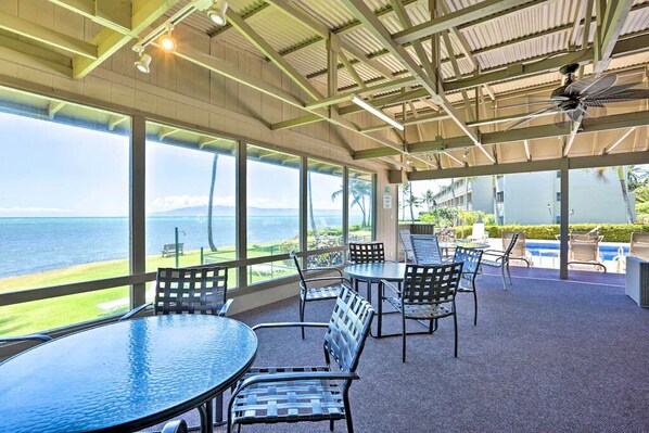 Guests can enjoy ocean views from this indoor seating area with tables and chairs.