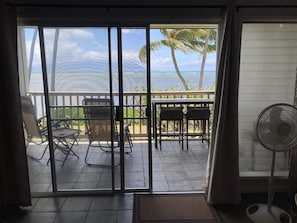 Enjoy ocean views from the balcony with a sliding glass door, featuring a table and chairs.
