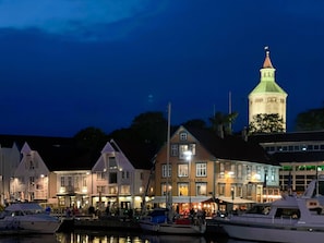 A waterfront area with buildings, a tower, and boats.