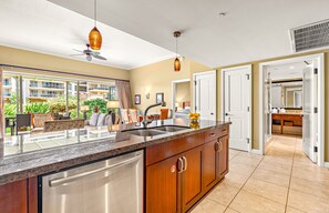 A modern kitchen with a large island, stainless steel appliances, and pendant lighting.