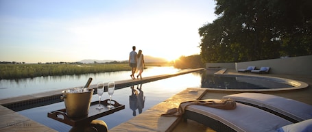 Outdoor pool, pool umbrellas, pool loungers. Sausage Tree Camp