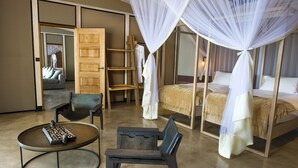 Ein Schlafzimmer mit Bett, Sessel, kleinem Tisch und Schrank.