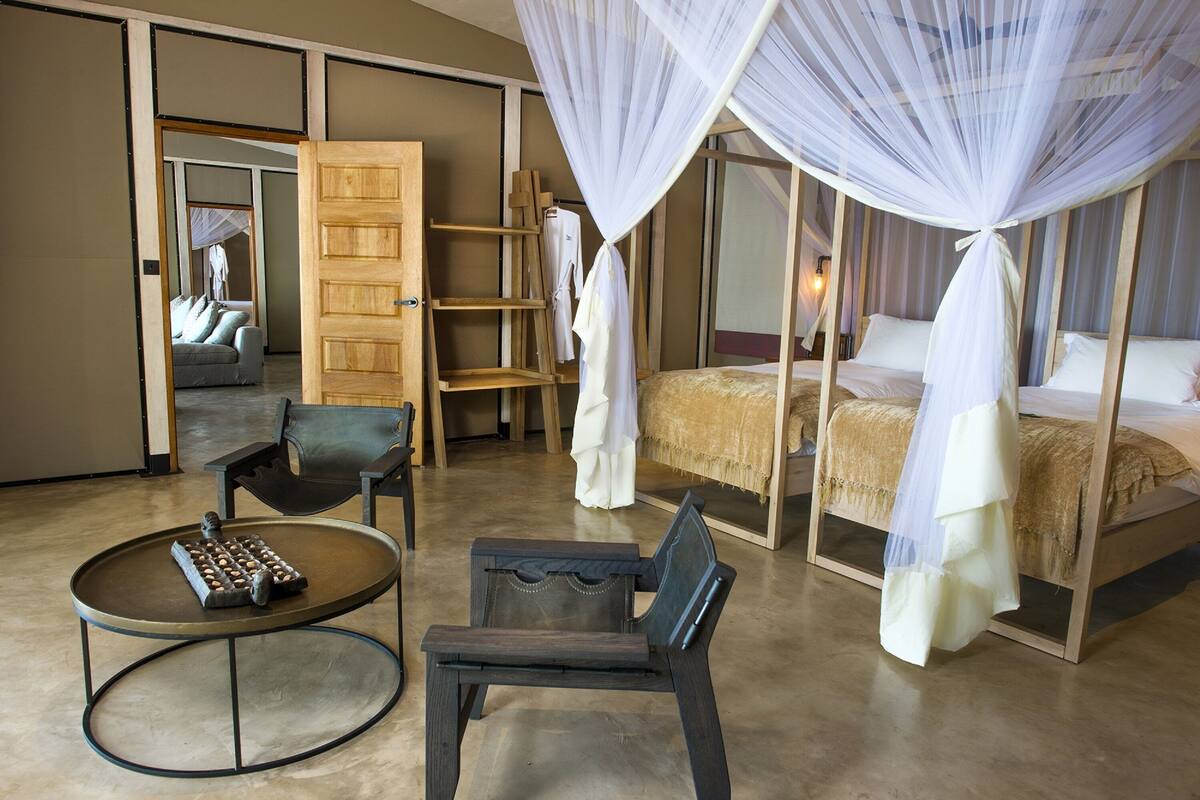 A bedroom with a bed, a chair, a small table, and a wardrobe.
