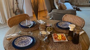 A dining table set with blue and white plates, a glass of wine, and a plate of fruit.