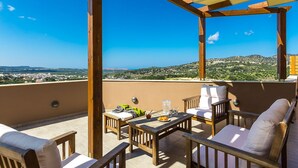 A covered outdoor seating area with a table and chairs, overlooking a scenic landscape. - Renta Villa Georgios, with Pool, BBQ & Playground, Close to the beach (Perama)