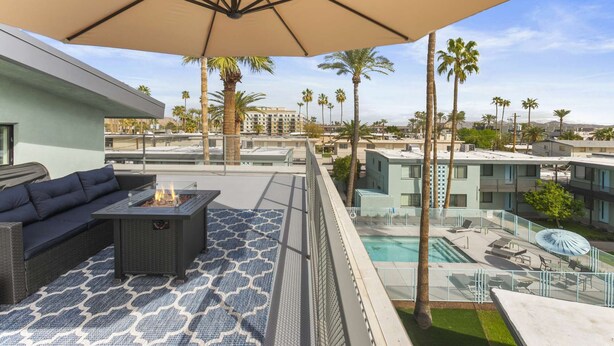 Une terrasse sur le toit avec un canapé, un foyer et un espace piscine.