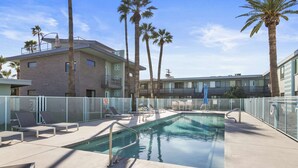 A rooftop pool with lounge chairs and palm trees, surrounded by a building with a modern design. - Scottsdale classic BoHo micro studio (Scottsdale)