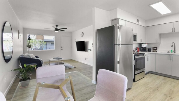 Ein modernes Apartment mit Wohnzimmer, Küche und Balkon.