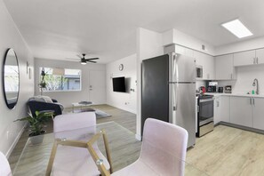 Un appartement moderne comprenant un salon, une cuisine et un balcon.