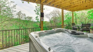 A hot tub on a wooden deck with a view of trees. - Pet-Friendly Branson Area Home: Hot Tub, Game Room (Reeds Spring)