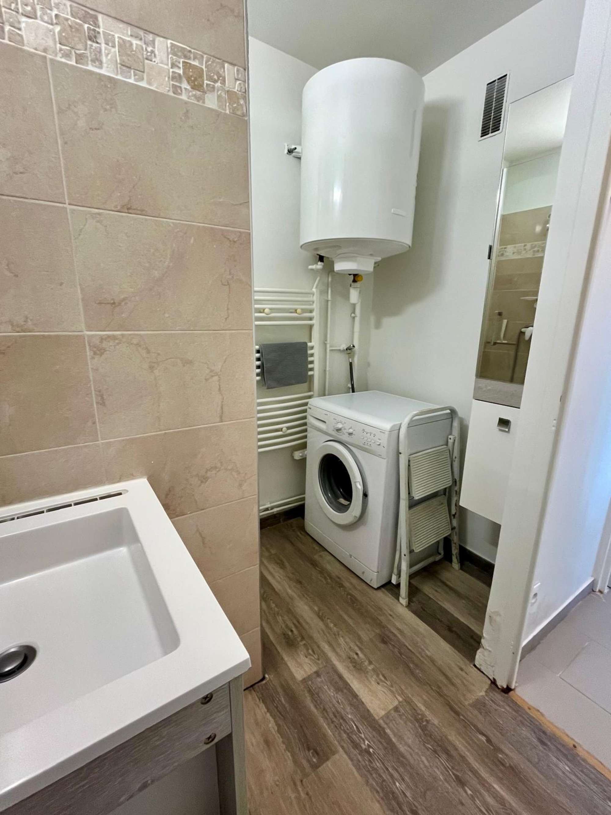 Un bagno funzionale con lavandino bianco, lavatrice e WC.