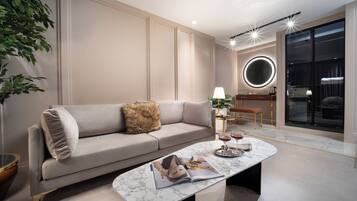 A modern living room with a sofa, coffee table, and a round mirror.