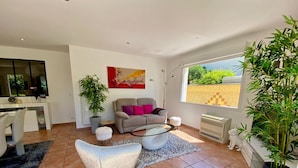A modern living room with a sofa, two armchairs, a coffee table, and a large window with a view. - 3-bedroom Villa in Mèze with Garden and Air Conditioning (Mèze)