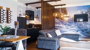 Una sala de estar moderna con chimenea, un comedor y una cocina.