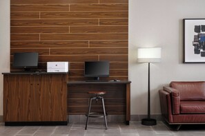A modern reception desk with two monitors, a printer, and a stool. - Four Points by Sheraton Yuma (Yuma)