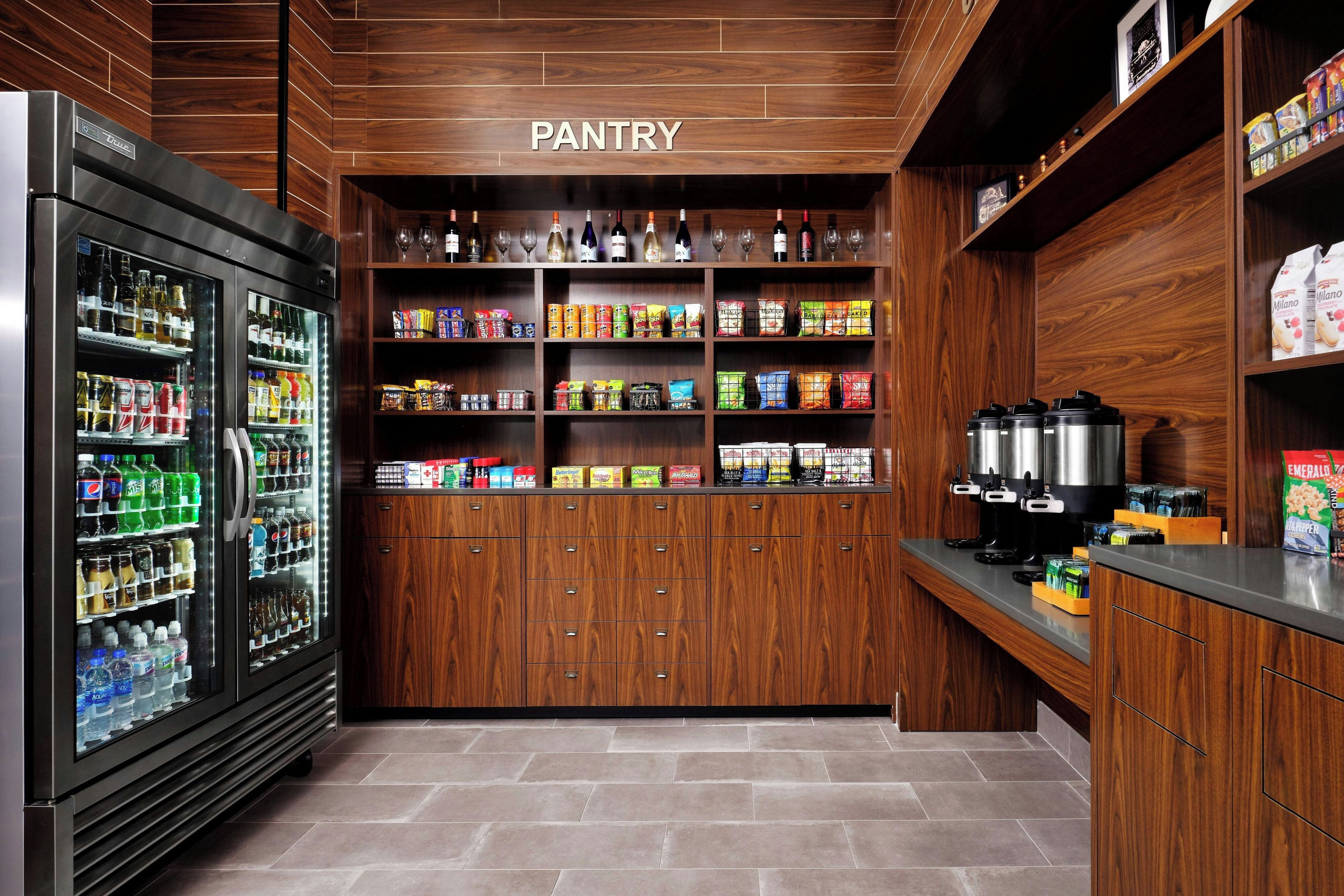 Un espace garde-manger avec des étagères remplies de boissons, de collations et de condiments.
