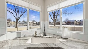 A kitchen with a large window, a sink, and a faucet. - Modern Farmhouse Retreat | 5BR | With Pool Views (Meridian)