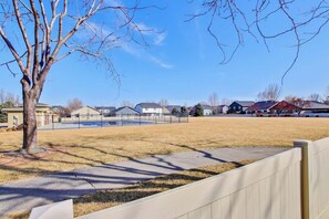 A residential area with houses, a fenced yard, and a tree.