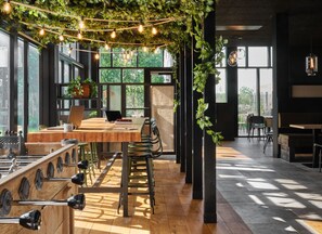 A modern interior with a wooden table, chairs, and a laptop on a desk.