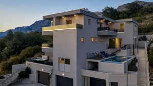 A modern multi-story building with a rooftop pool, balconies, and a garage. - Luxury Apartment Podgora-Zora (Podgora)