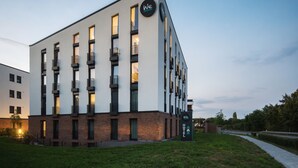 Un hotel modern amb una teulada plana, diversos balcons i un rètol que indica que és un hotel.