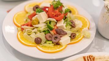 A plate of salad with various vegetables and cheese.