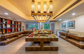 A spacious room with a central buffet table, wooden shelving with decorative items, and a ceiling with recessed lighting. - Glenview Resort Kasauli, a member of Radisson Individuals (Kasauli)