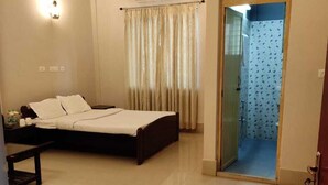 A hotel room with a bed, bedside table, and a wardrobe.