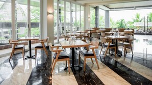 A spacious restaurant with large windows, modern furniture, and a clean, polished floor. - Aston Gorontalo Hotel & Convention Center (Gorontalo)