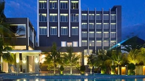 A modern hotel with a pool, featuring a multi-story structure with evenly spaced windows and a flat roof. - Aston Gorontalo Hotel & Convention Center (Gorontalo)