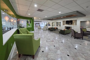 A spacious lobby with a reception desk, seating area, and a television mounted on the wall. - Wingate Houston near Reliant Park/Medical Center (Houston)