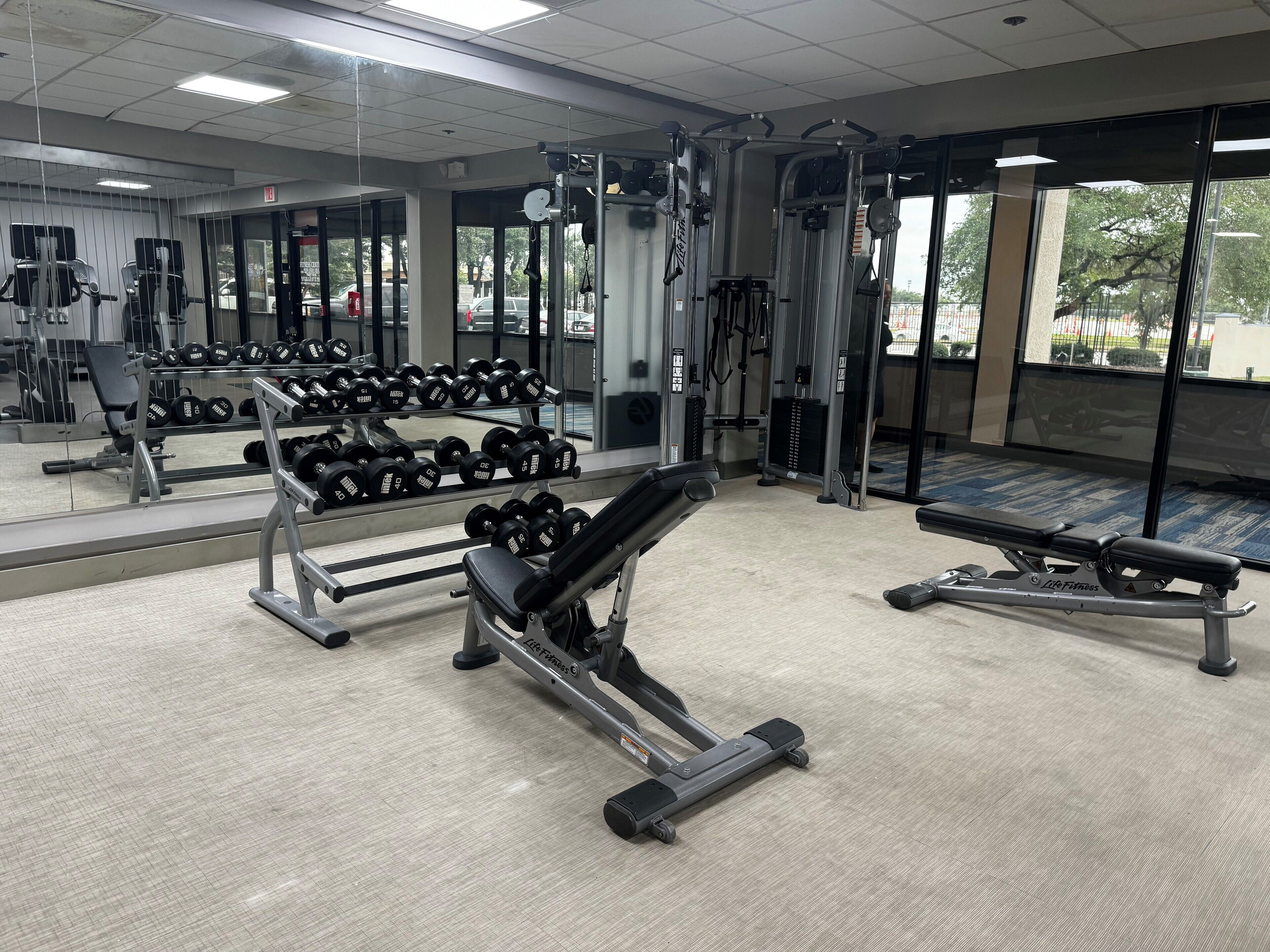 Een sportschool met gewichthefapparatuur, dumbbells en cardioapparaten.