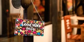 A colorful sign with the text "Good vibes only" hanging on a metal pole. - Woodstock Resort (Shillong)