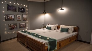 A double bed with a wooden frame, two pillows, a green and white checkered blanket, and string lights on the wall. - Woodstock Resort (Shillong)