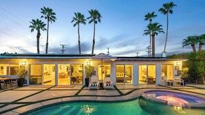Ein modernes Haus mit Schwimmbad, mehreren Zimmern und einer Terrasse.