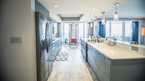 A modern kitchen with a central island, built-in appliances, and a dining area with a view.