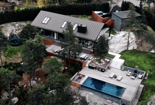 Una casa moderna con una terraza grande y una piscina.