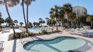 A pool area with lounge chairs and palm trees. - Shorewood 403- Oceanfront 4th Floor Condo (Hilton Head Island)