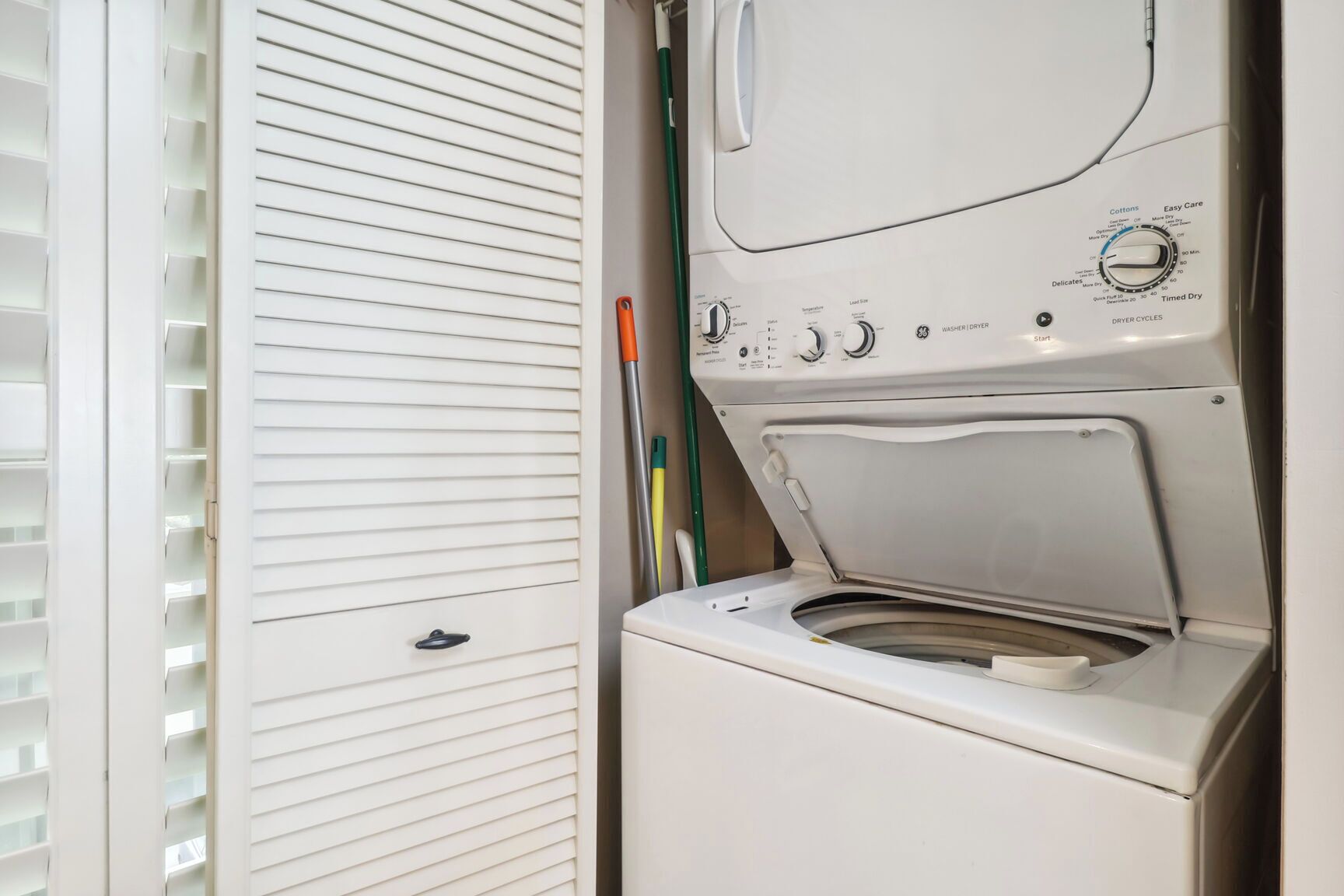 Een voorlader wasmachine met bedieningspaneel, een witte buitenkant en een deur met horizontale lamellen.