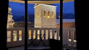 A balcony with a view of a stone tower at dusk.