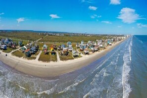 Un pueblo costero con propiedades frente a la playa y una playa de arena.