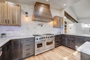 Enjoy cooking in this kitchen with a Viking range, dark wood cabinetry, and a large island with ample workspace.