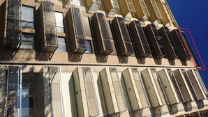 Un immeuble à plusieurs étages, doté de nombreux balcons et fenêtres.