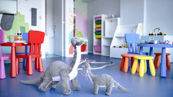Una habitación con sillas coloridas, un juguete de dinosaurio y un suelo azul.