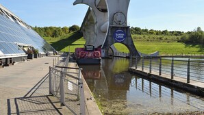 Une structure moderne à la conception circulaire, une enseigne accueillant les visiteurs de Scottish Canals, et une étendue d’eau au premier plan.