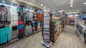 A clothing store with racks of folded clothes and a display of various items.