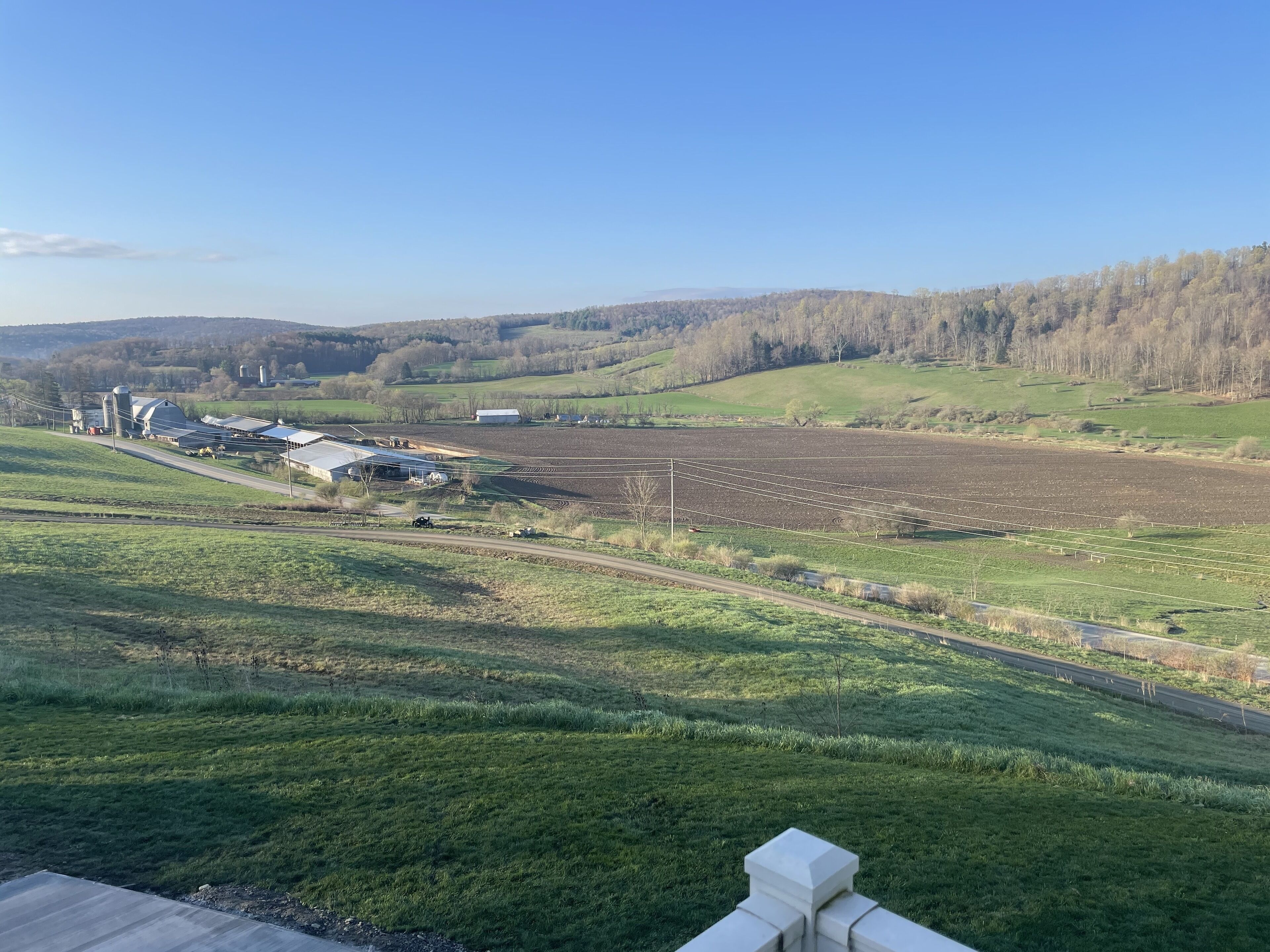 Paisaje rural con una granja, graneros y campos abiertos.