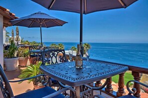 A balcony with a table and chairs, overlooking the ocean. -  Oceanfront Hamilton Cove Penthouse suite with stunning panoramic views! (Avalon)