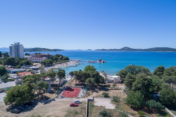 An aerial view of a coastal area with a beach, a water park, and a hotel named "Punta".