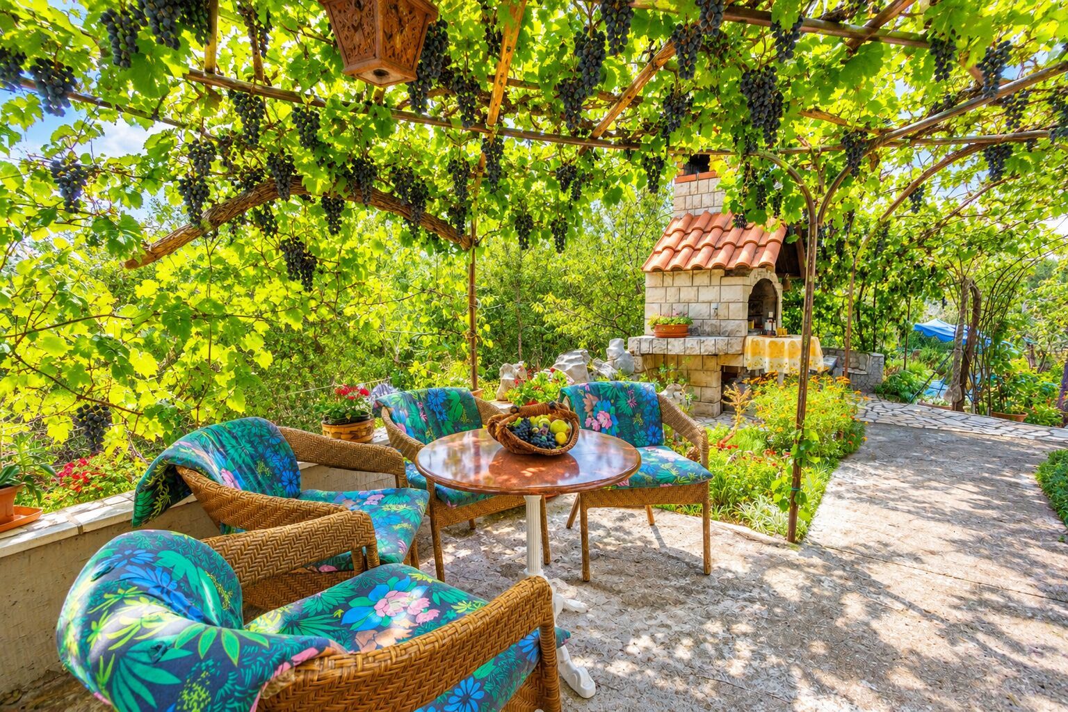 An outdoor seating area with wicker furniture and a stone fireplace.